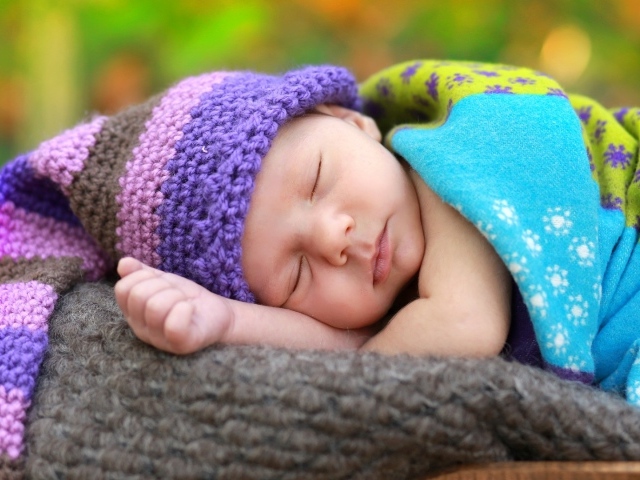 Маленький спящий младенец в вязаной шапке 