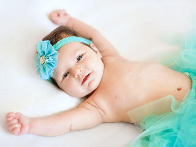 Милая маленькая малышка с цветком бирюзового цвета на голове