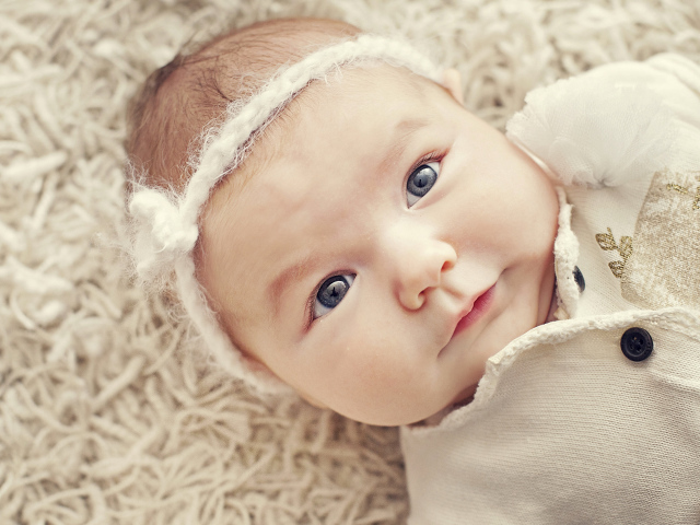 Красивая голубоглазая малышка с повязкой на голове