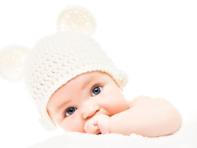 Голубоглазый младенец с белой шапке с ушками на белом фоне