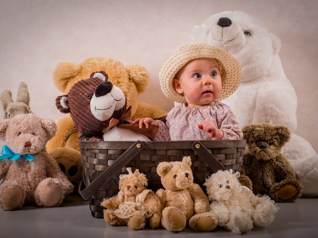 Забавный грудной ребенок в корзине с мягкими игрушками