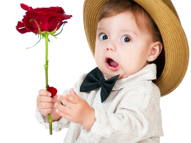 Забавный маленький мальчик в шляпе с красной розой в руке