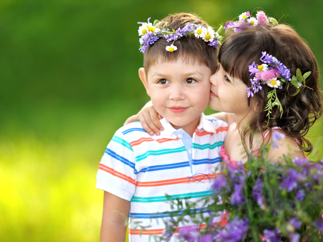 Маленькие мальчик и девочка с венками из полевых цветов на голове