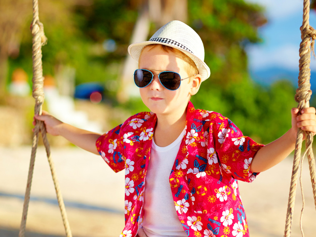 Маленький мальчик в белой шляпе и солнечных очках