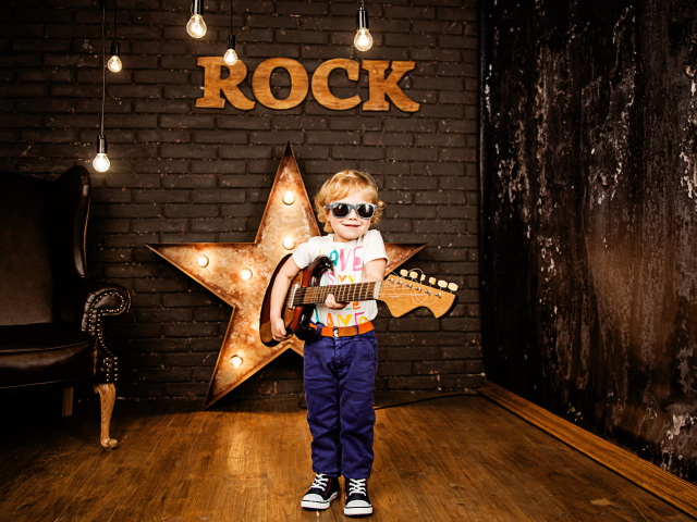 Маленький мальчик в модных очках с гитарой
