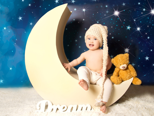 Маленький мальчик с плюшевым мишкой сидят на месяце