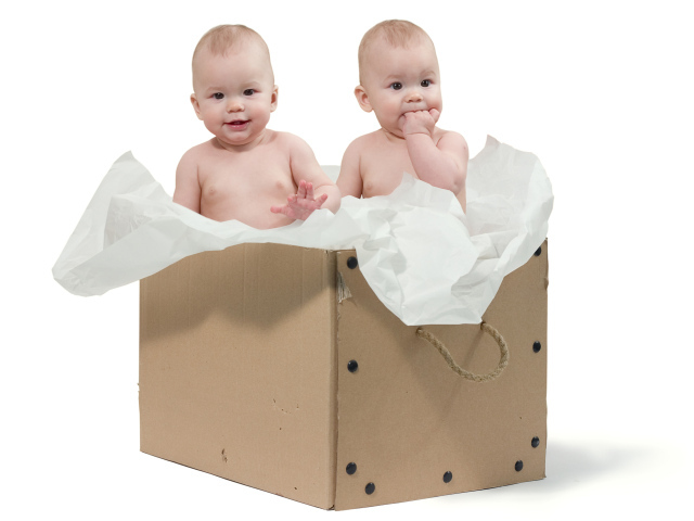 Маленькие дети сидят в картонной коробке с бумагой