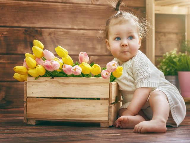 Маленькая забавная девочка с букетом тюльпанов