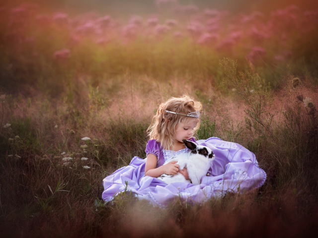 Маленькая девочка в красивом платье с кроликом в руках