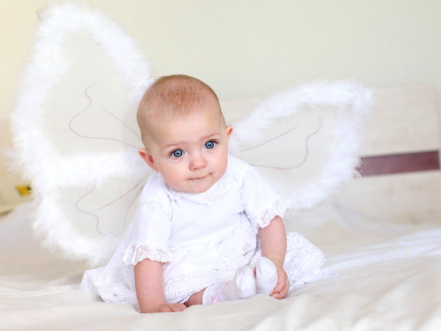 Маленькая девочка в красивом белом платье с крыльями