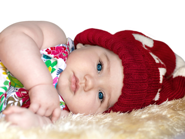 Маленькая девочка в красной вязаной шапке