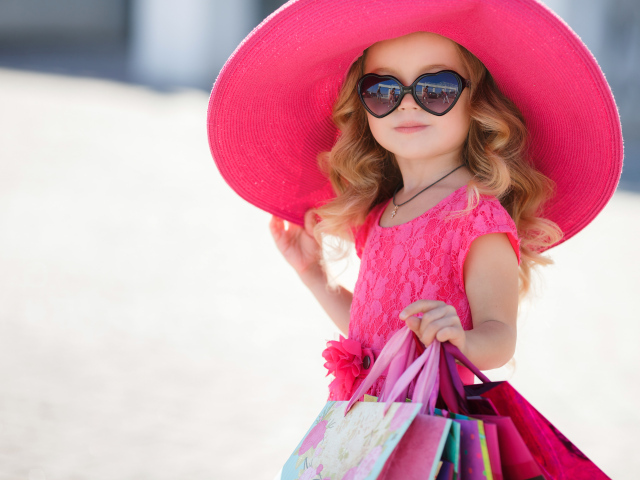 Маленькая девочка модница в большой розовой шляпе