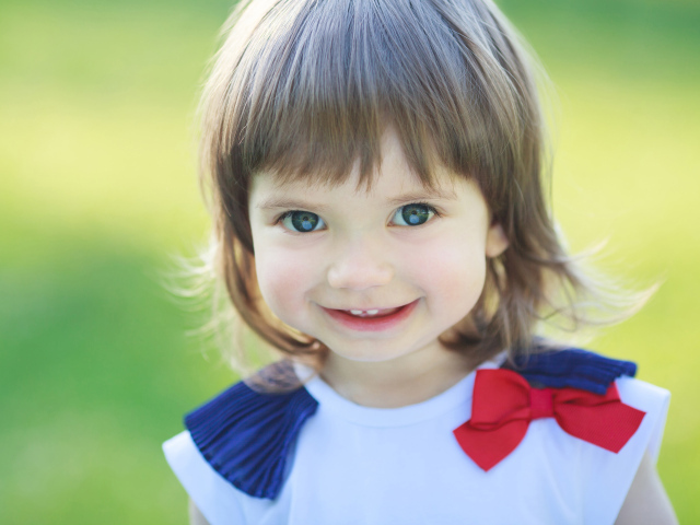 Милая улыбающаяся зеленоглазая маленькая девочка