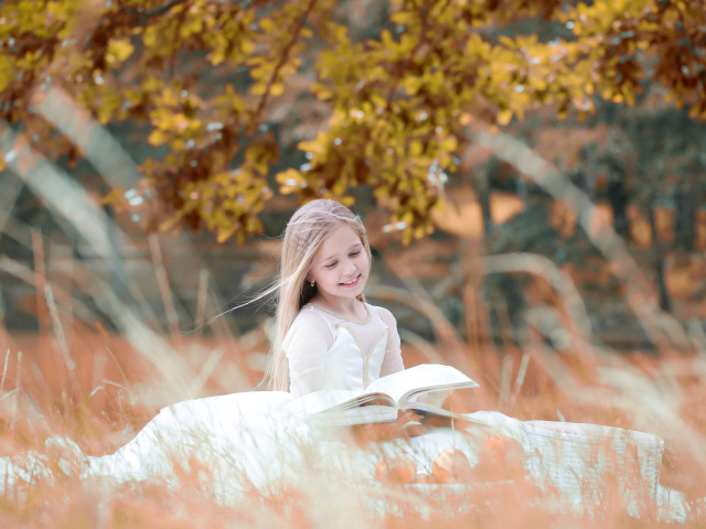 Улыбающаяся девочка в белом платье читает книгу
