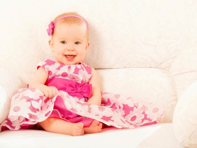 Улыбающаяся маленькая девочка в красивом розовом платье