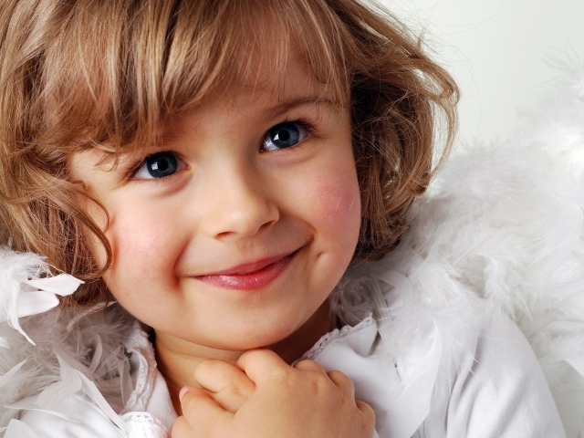 Маленькая голубоглазая девочка в костюме ангела 