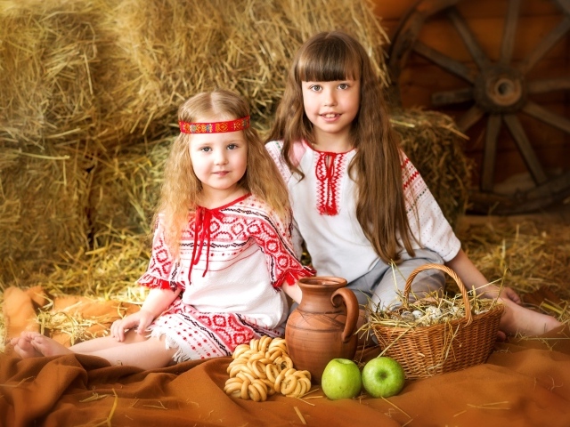 Две маленькие девочки в красивых костюмах с угощениями