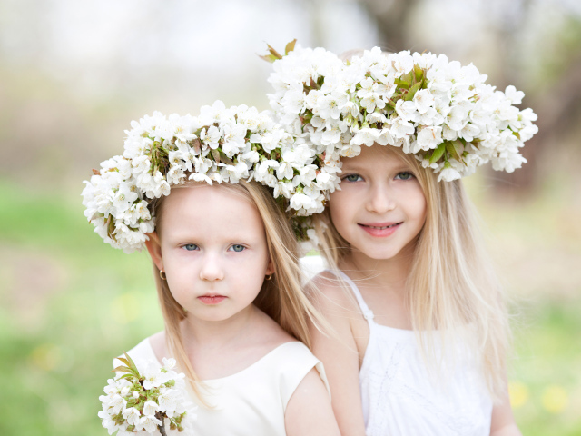 Две маленькие девочки с венками из белых цветов на голове