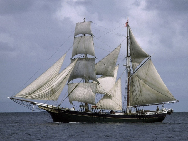 Корабль с белыми парусами в море 