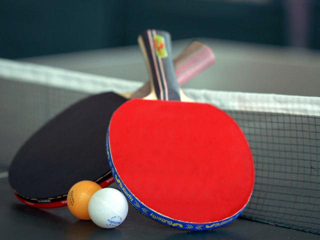 Ракетки для настольного тенниса и мячи на столе  
