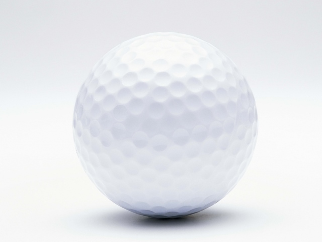 Белый мяч для гольфа на белом фоне крупным планом 