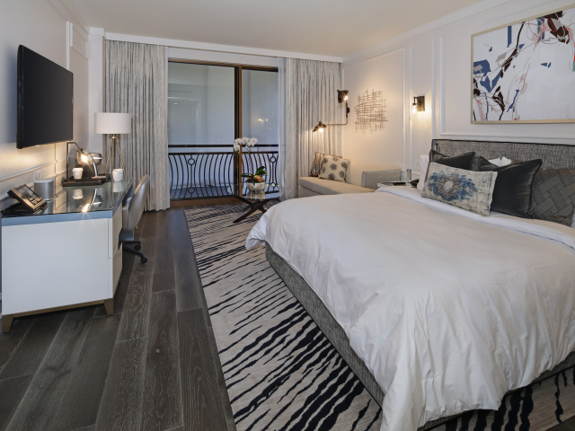 Спальня с большой кроватью и телевизором на стене