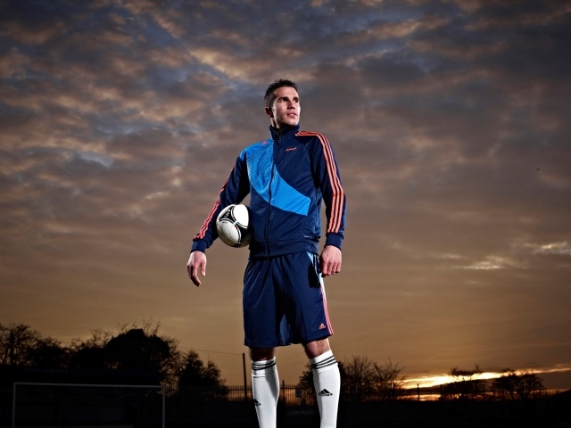 Футболист  Робин ван Перси с мячом на фоне неба