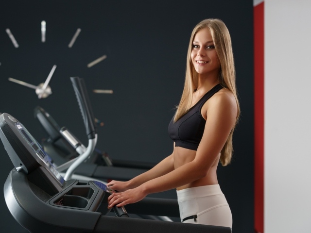 Девушка спортсменка на беговой дорожке 