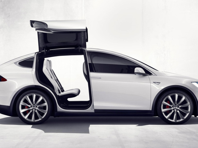 Белый электромобиль Тесла с открытыми дверями  