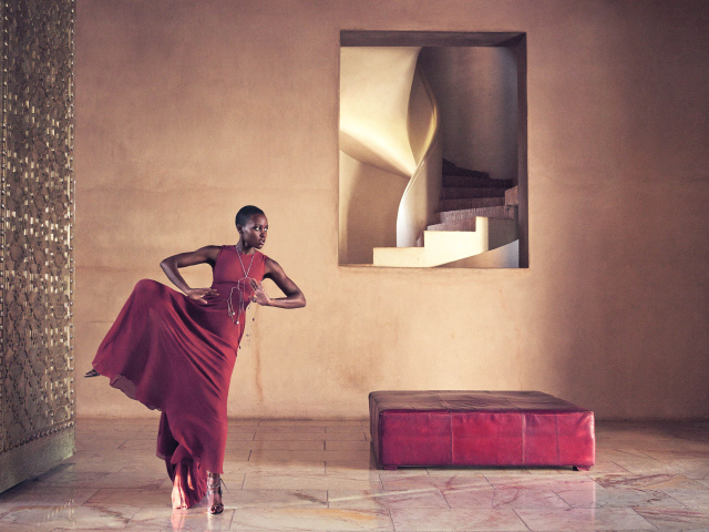 Молодая актриса Люпита Нионго танцует в красном платье