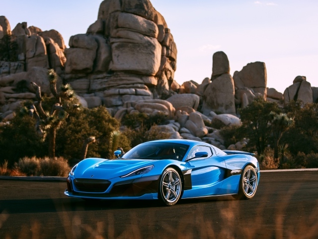 Голубой спортивный автомобиль  Rimac C_Two на фоне гор