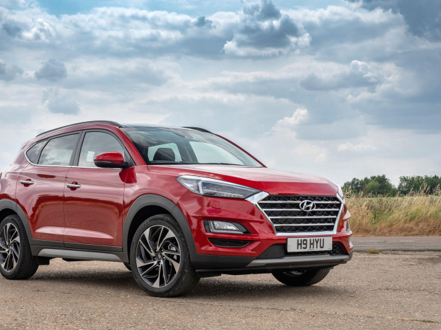 Красный автомобиль Hyundai Tucson, 2019 года под пасмурным небом