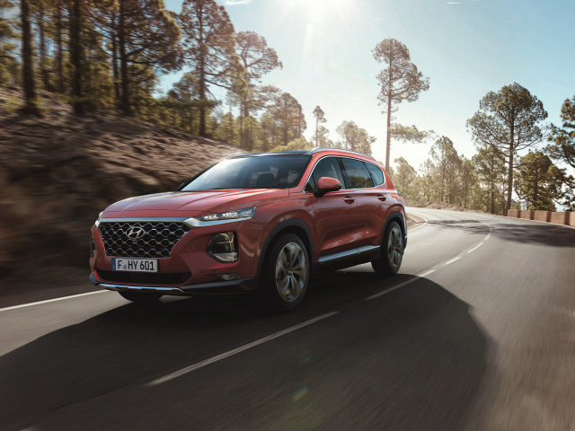 Красный автомобиль Hyundai Santa Fe, 2018 года на трассе