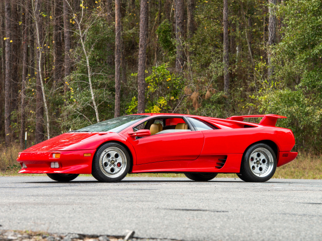 Красный спортивный автомобиль Lamborghini Diablo на фоне леса