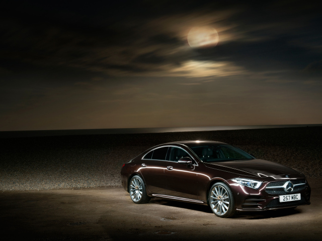 Коричневый автомобиль Mercedes Benz CLS 400 D AMG 2018 года на фоне луны