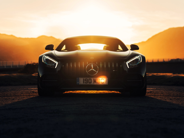 Стильный черный автомобиль Mercedes-AMG GT C на фоне заката