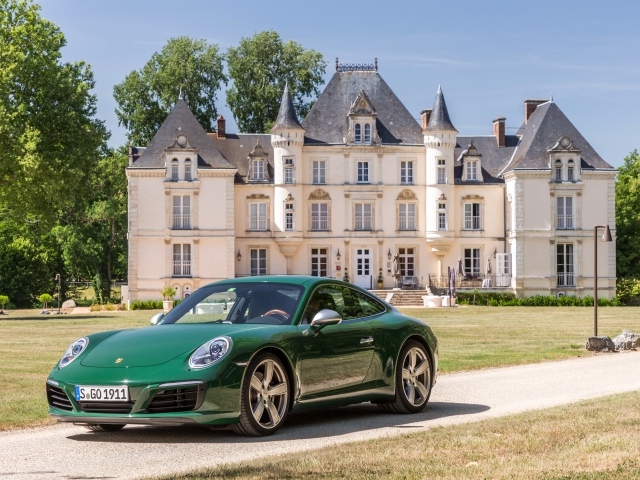 Зеленый спортивный автомобиль Porsche 911 Carrera на фоне дома