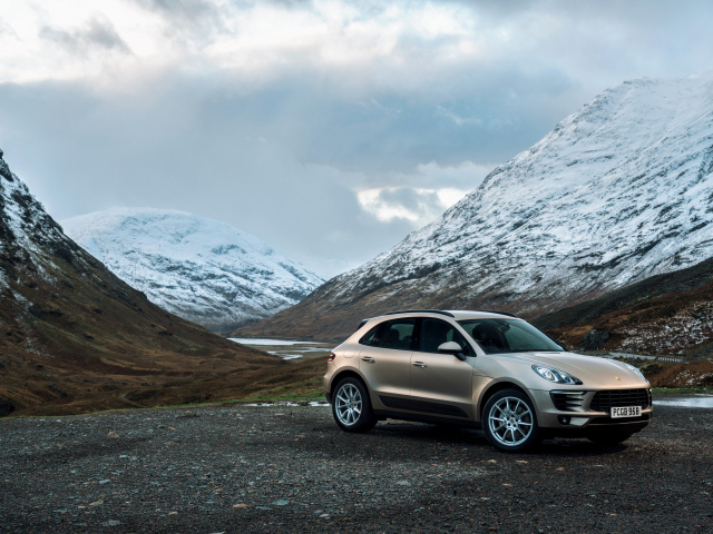 Внедорожник Porsche Macan на фоне заснеженных гор 