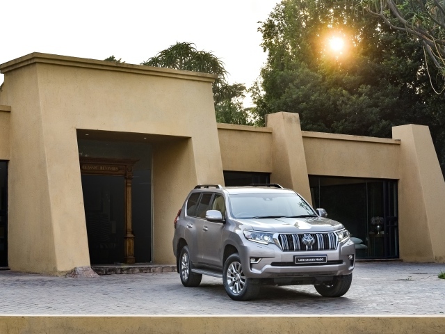 Серебристый внедорожник Toyota Land Cruiser Prado VX-L, 2018 года  в лучах солнца 
