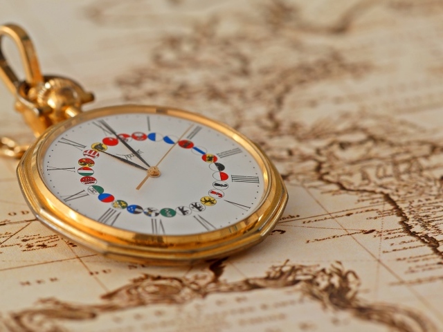 Карманные часы в золотой оправе лежат на карте