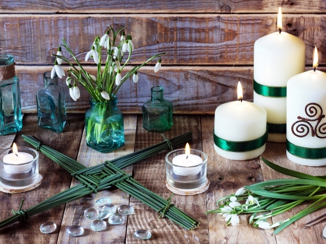 Букет подснежников на столе с зажженными свечами