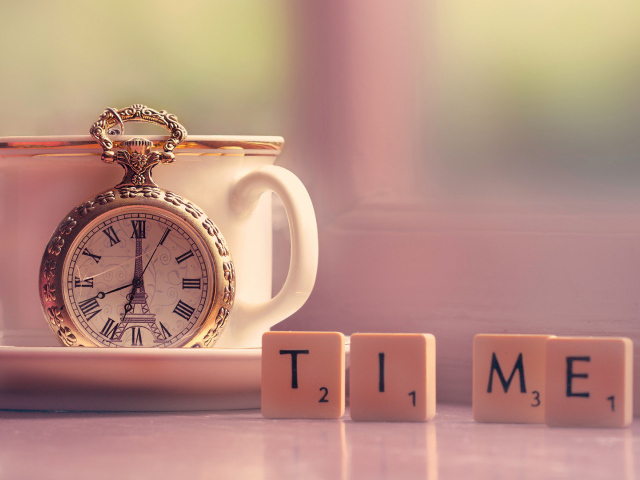 Часы с чашкой на столе с кубиками 