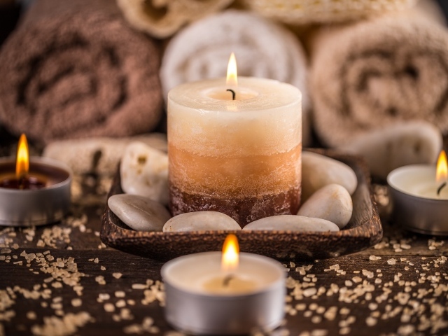 Зажженная свеча с камнями для SPA процедур