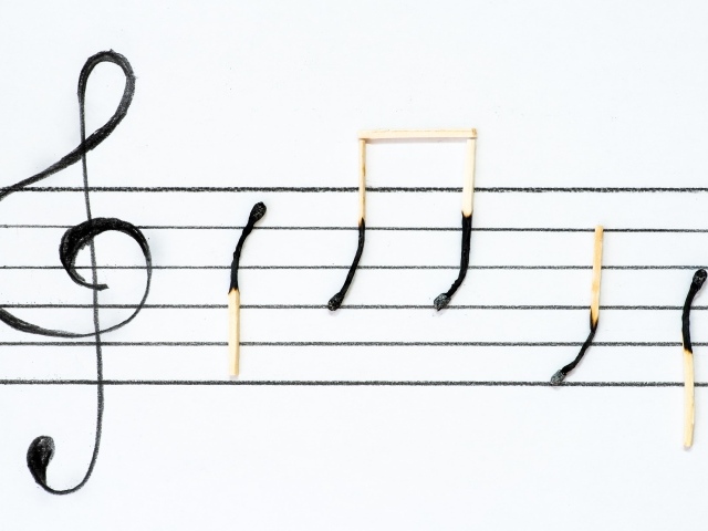 Ноты из сгоревших спичек на белом фоне