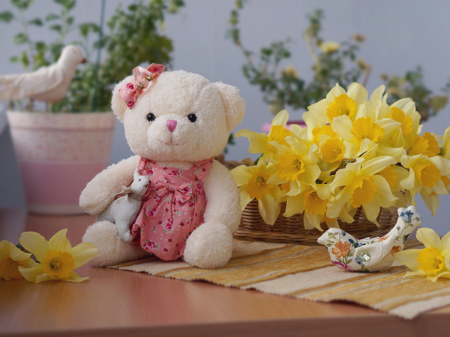 Плюшевый мишка на столе с букетов нарциссов