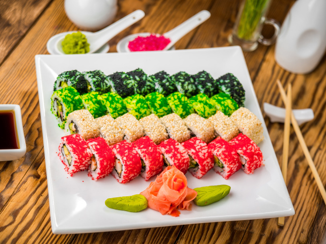 Аппетитные роллы с имбирем и соусом васаби на белой тарелке 