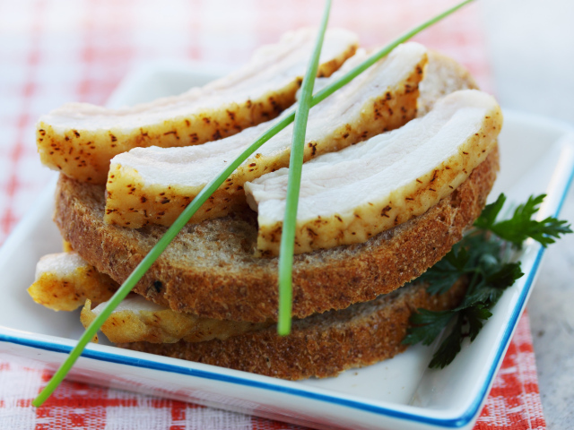 Черный хлеб с салом и зеленью на столе