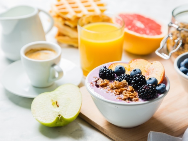 Завтрак с овсянкой, ягодами, фруктами и свежим соком на столе