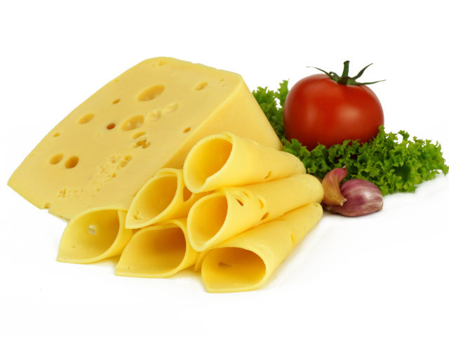 Сырная нарезка с помидором, листьями салата и чесноком на белом фоне