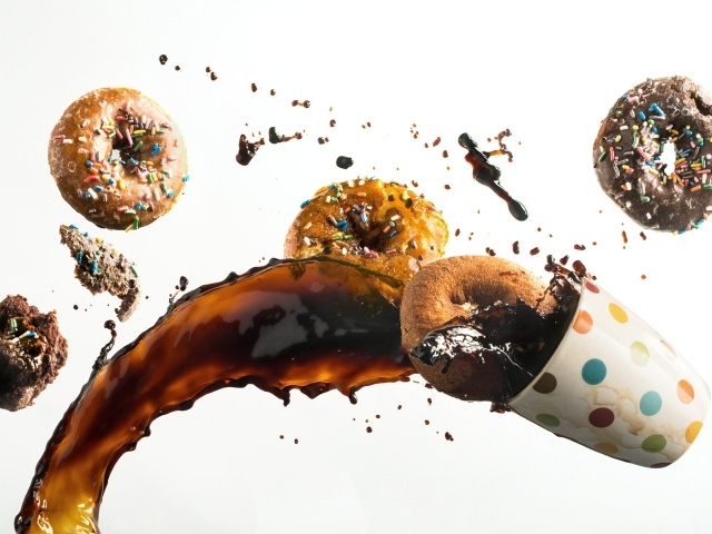 Пончики с чашкой кофе на белом фоне